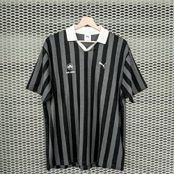 Polo von Puma in der Farbe Schwarz und Grau gestreift Kleeblatt Logo und est. 1903 gestsickt in Off-White auf der Brust Details am Kragen in der Farbe off-white